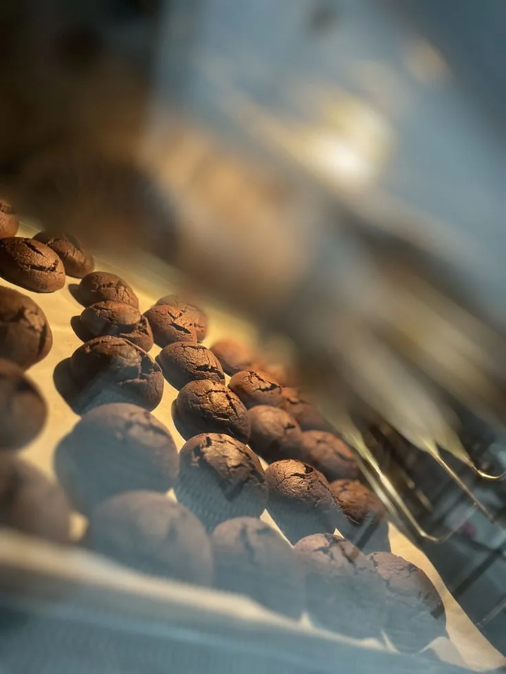 Fresh baked goods displayed behind glass in warm light
