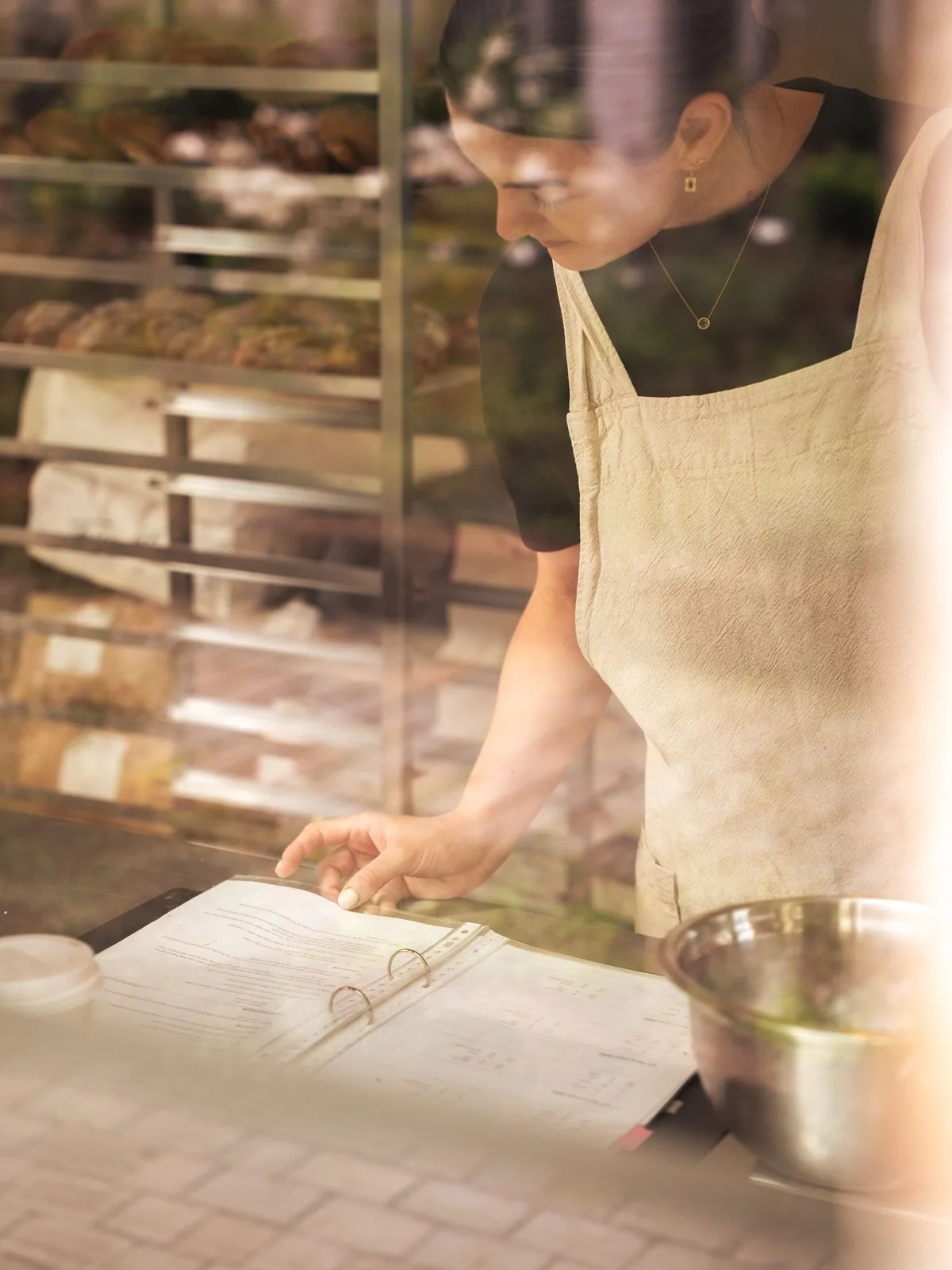Baker reviewing a recipe through the bakery window