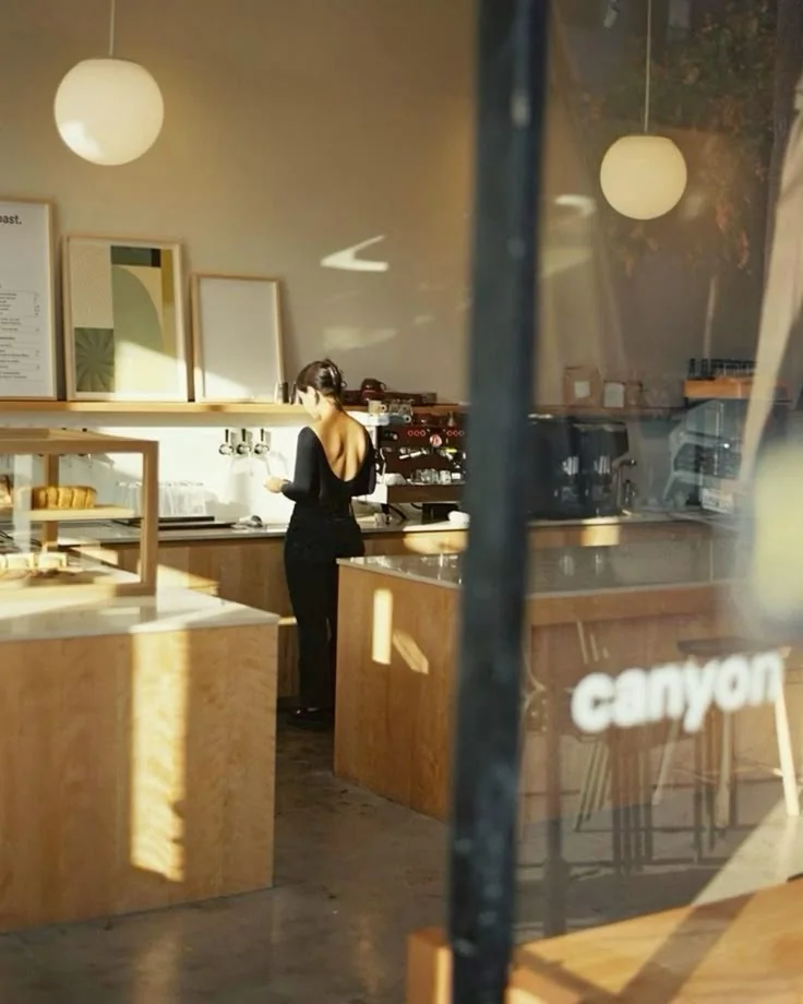 Barista at work photographed through a café window