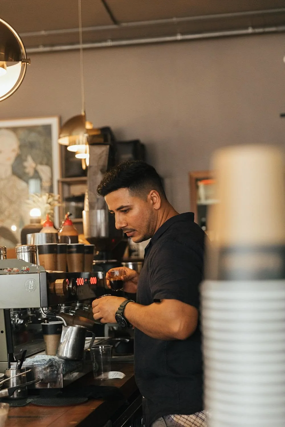 Barista preparing coffee behind the machine