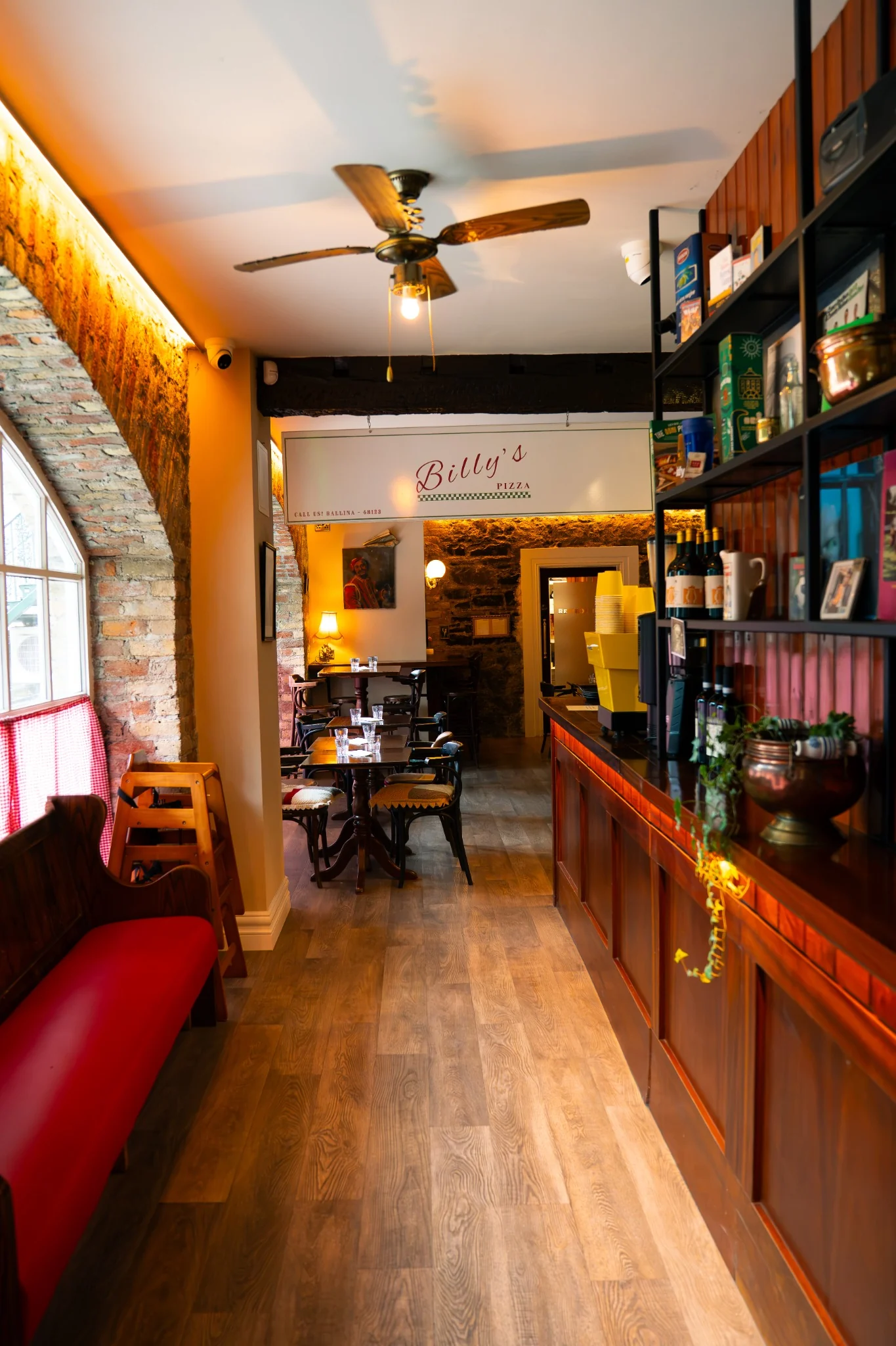Warm interior of Billy’s Pizza in Ballina with dining tables and bar