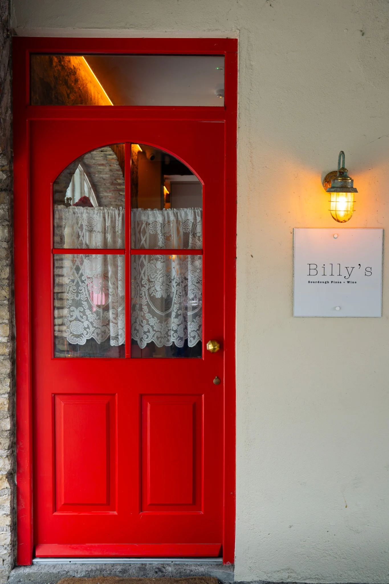 Red entrance door and Billy’s Pizza branding in Ballina