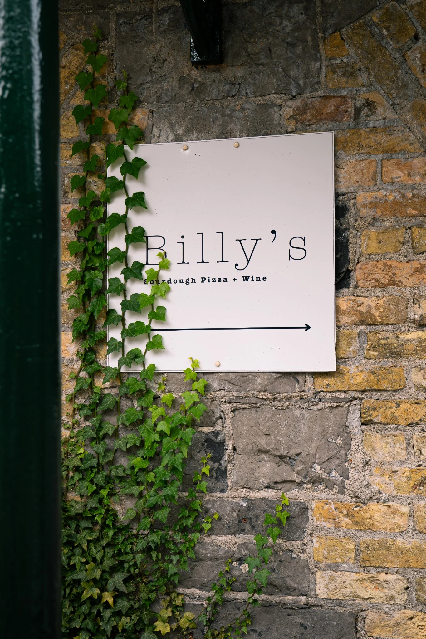 Billy’s Sourdough Pizza and Wine sign on the stone exterior in Ballina