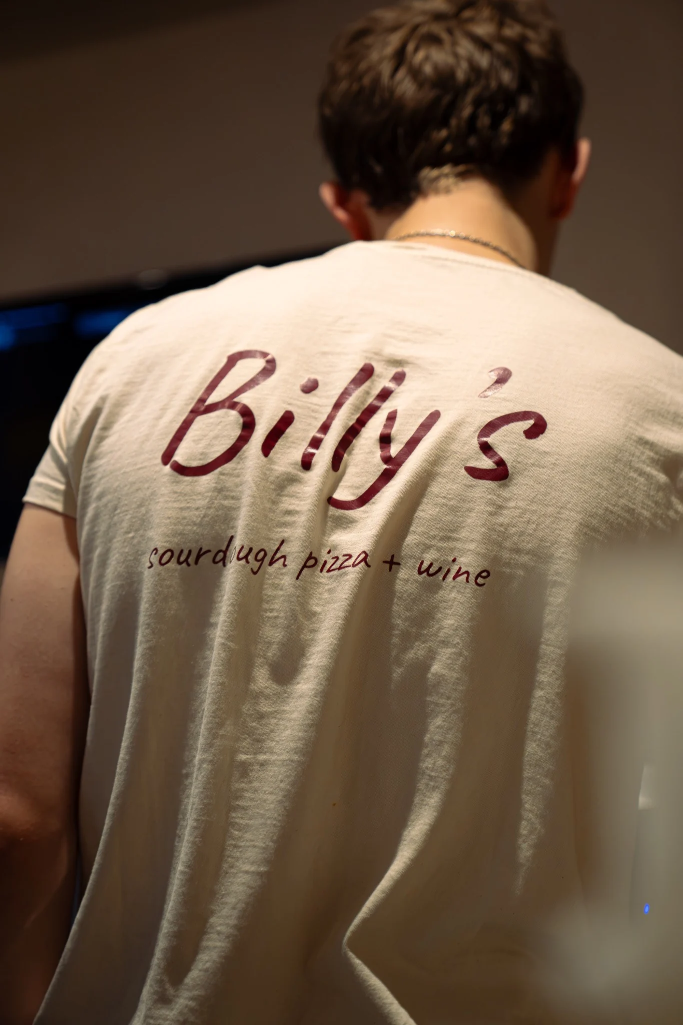 Billy’s Pizza team member wearing branded sourdough pizza and wine shirt