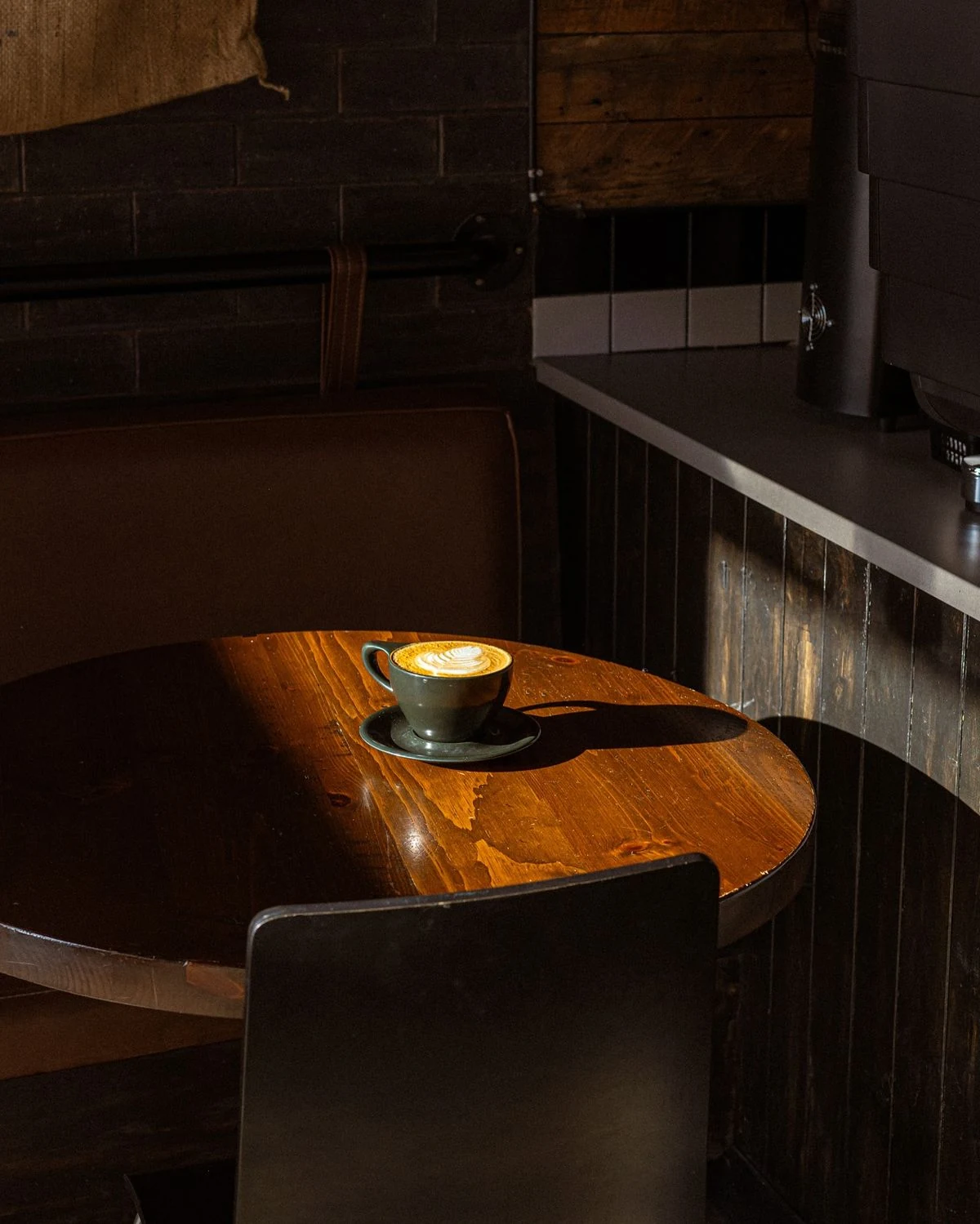 Latte in warm sunlight on a wooden café table