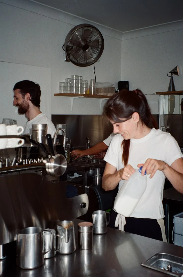 Café team working together behind the espresso machine