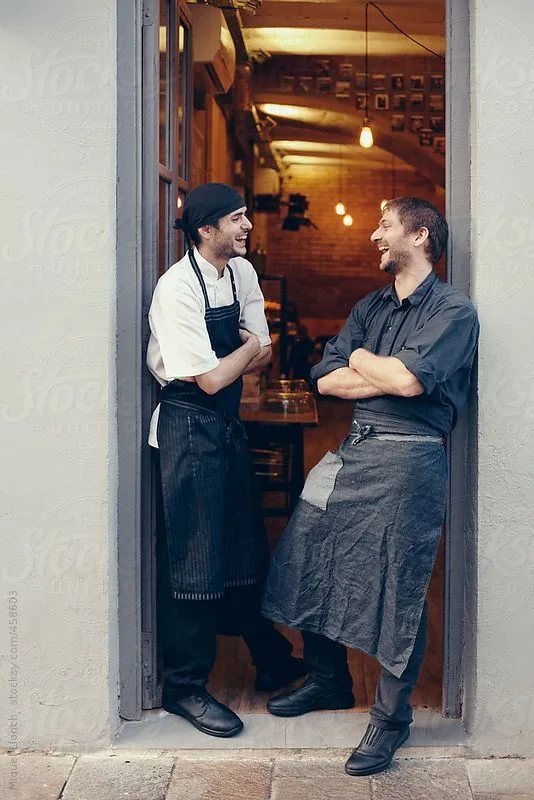 Two chefs sharing a candid moment outside a restaurant