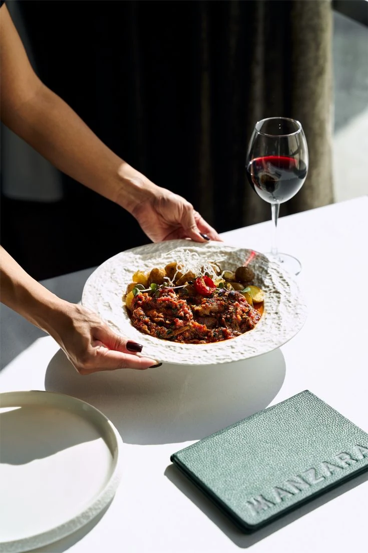 Fine dining plate and red wine in a bright hospitality setting on Isola di San Pietro in Sardinia