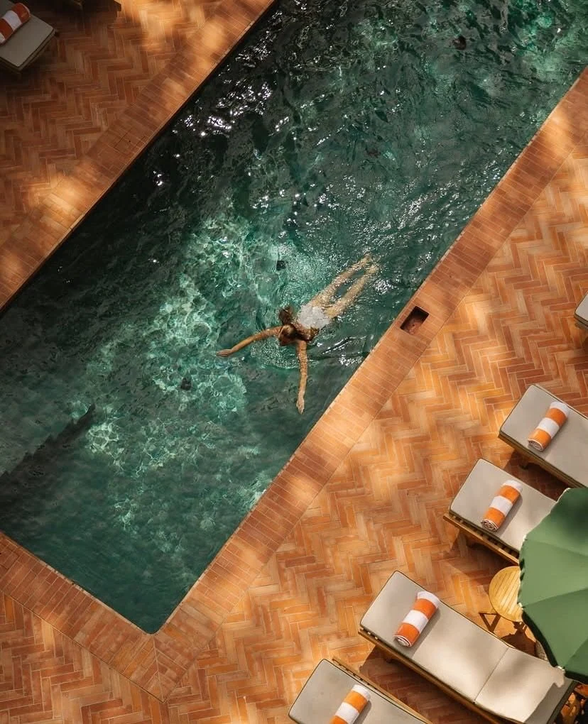 Aerial view of a swimmer in a green hotel pool on Isola di San Pietro in Sardinia