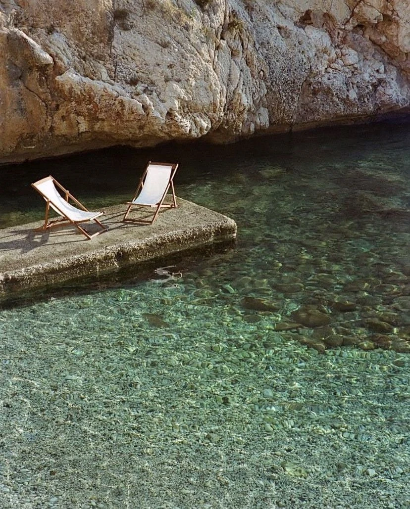 Deckchairs beside a secluded turquoise cove on Isola di San Pietro in Sardinia