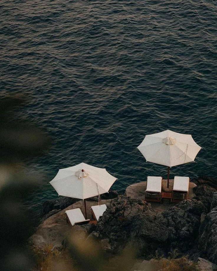 White parasols and loungers overlooking the Mediterranean on Isola di San Pietro in Sardinia