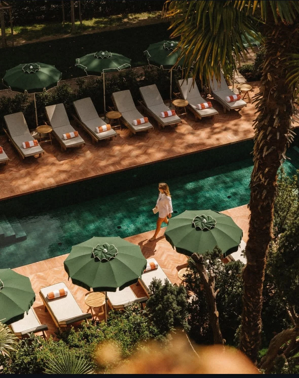 Hotel pool and garden with green parasols on Isola di San Pietro in Sardinia