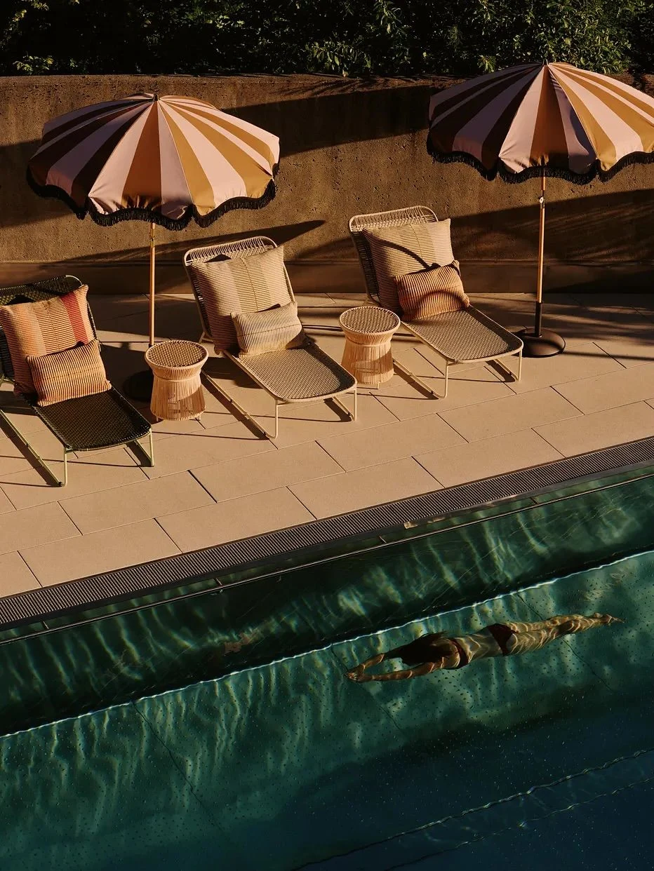 Swimmer crossing a sunlit hotel pool on Isola di San Pietro in Sardinia