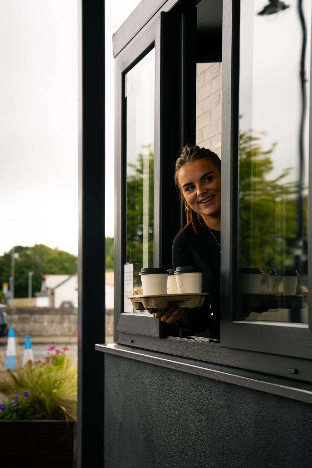 Jimmys team member serving takeaway coffees through the drive thru window