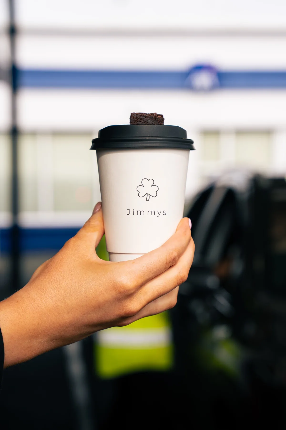 Branded Jimmys takeaway coffee cup held outside the Ballina drive thru
