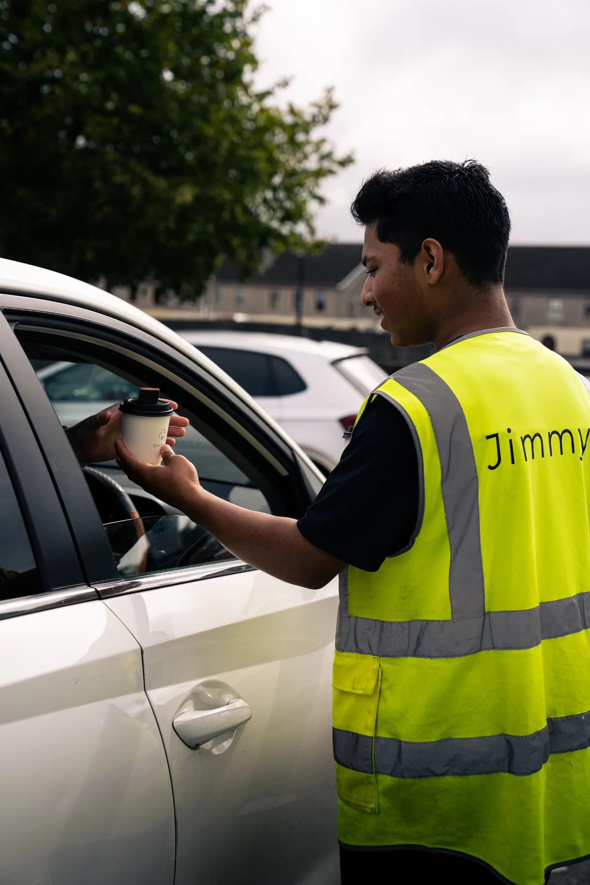 Jimmys drive thru team member handing coffee to a customer