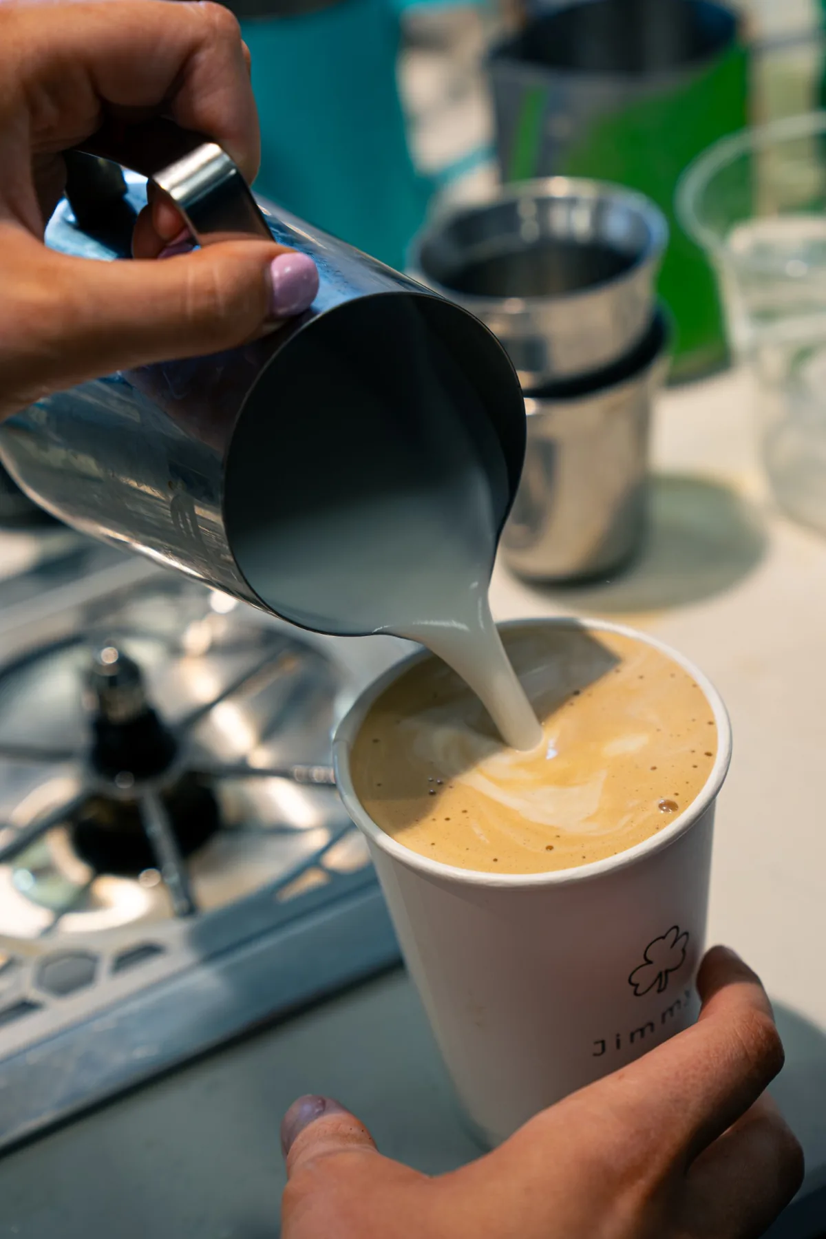 Milk being poured into a takeaway coffee at Jimmys