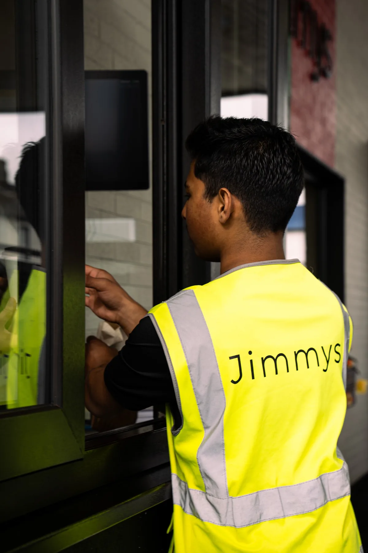 Jimmys drive thru staff member serving at the window