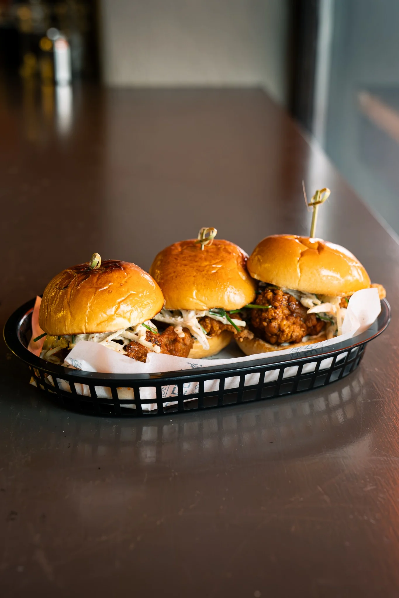Three chicken sliders served in a basket at Jimmy’s