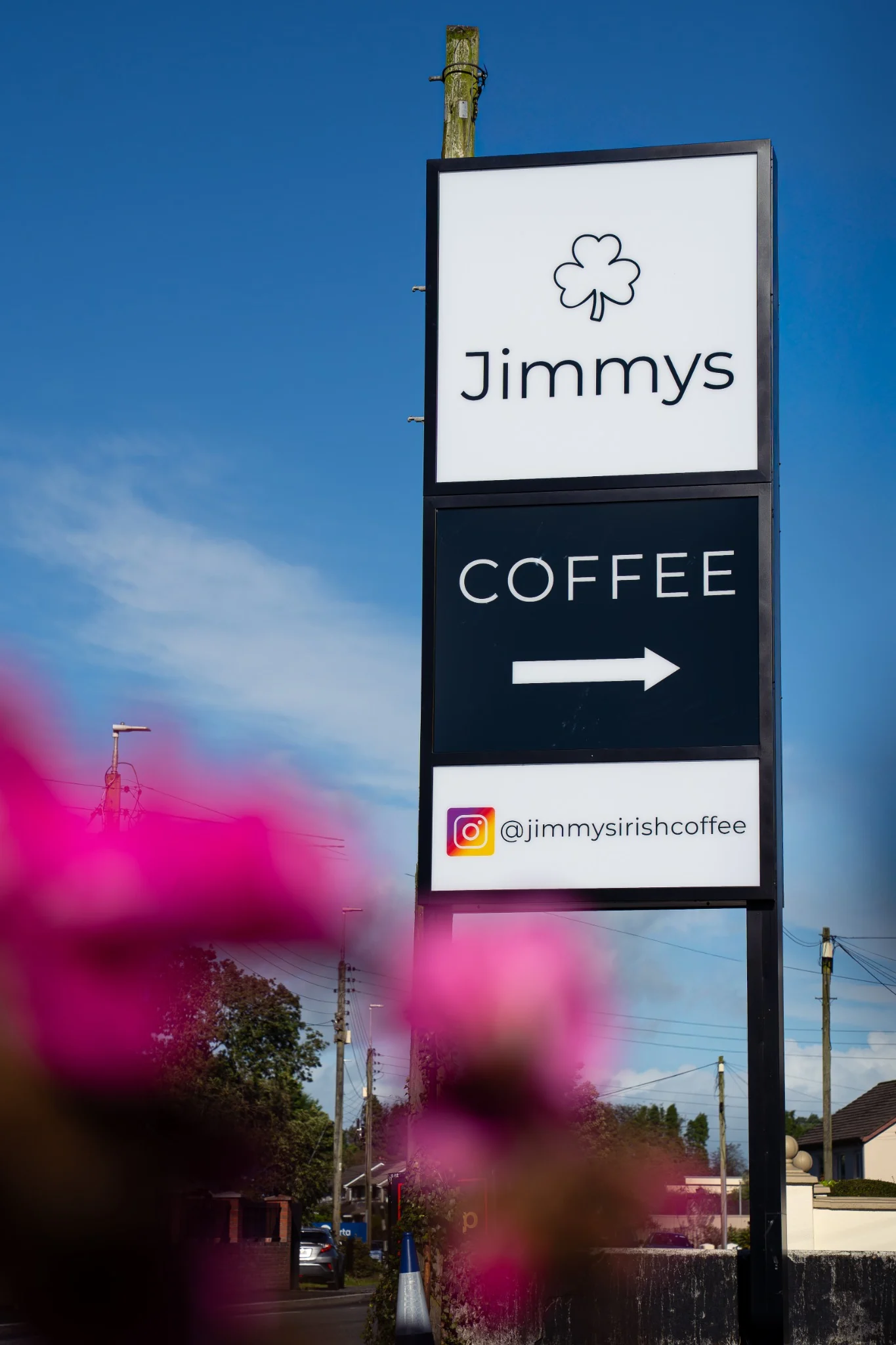 Jimmy’s Coffee roadside sign photographed beneath a clear blue sky