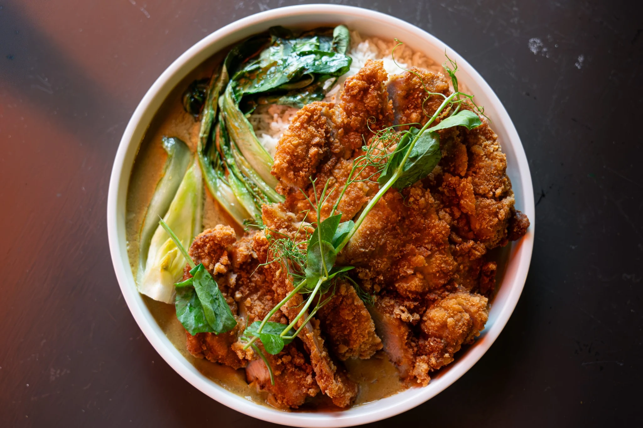Crispy chicken dish with greens photographed from above