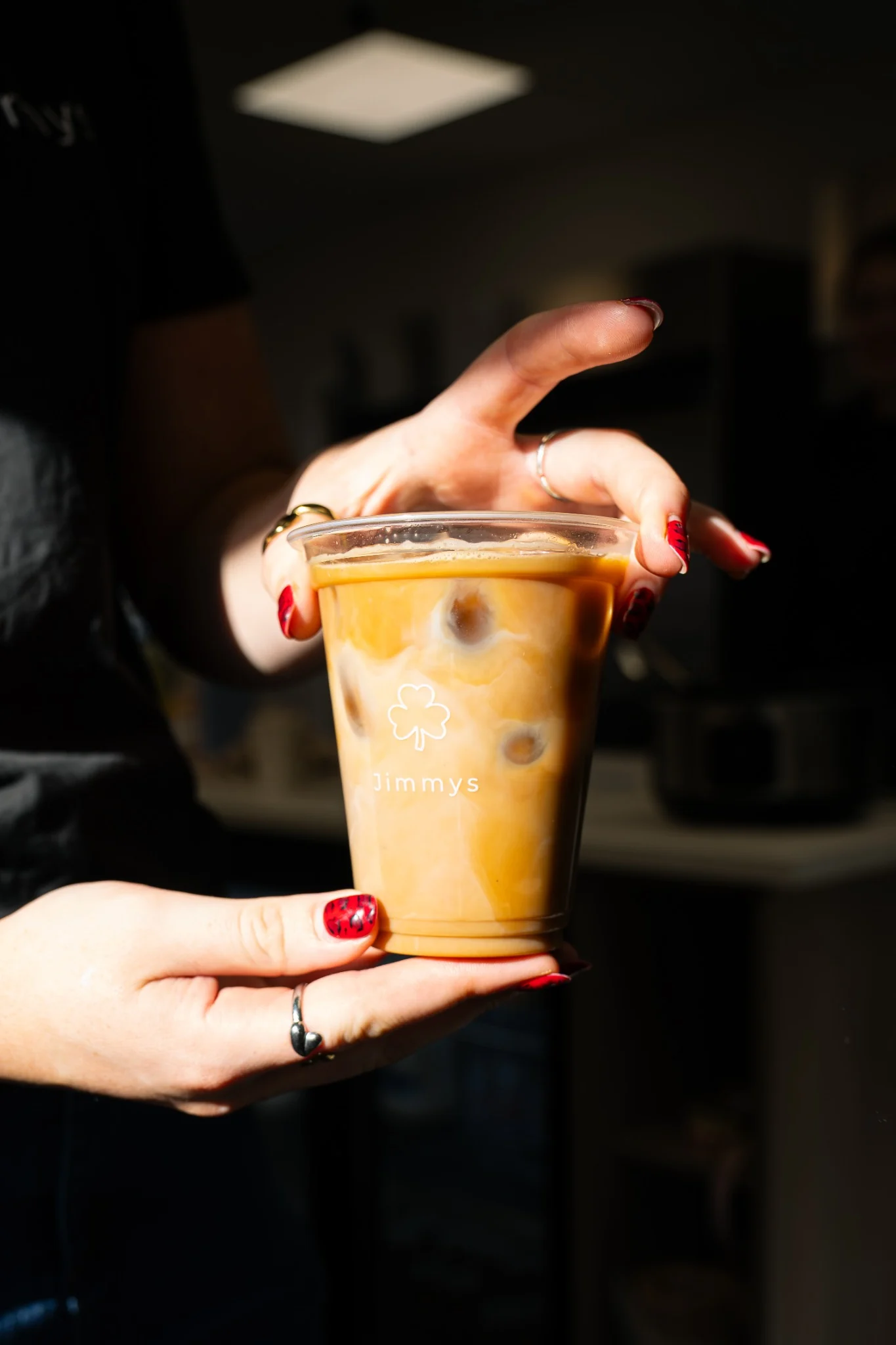 Iced coffee held in warm directional light at Jimmy’s