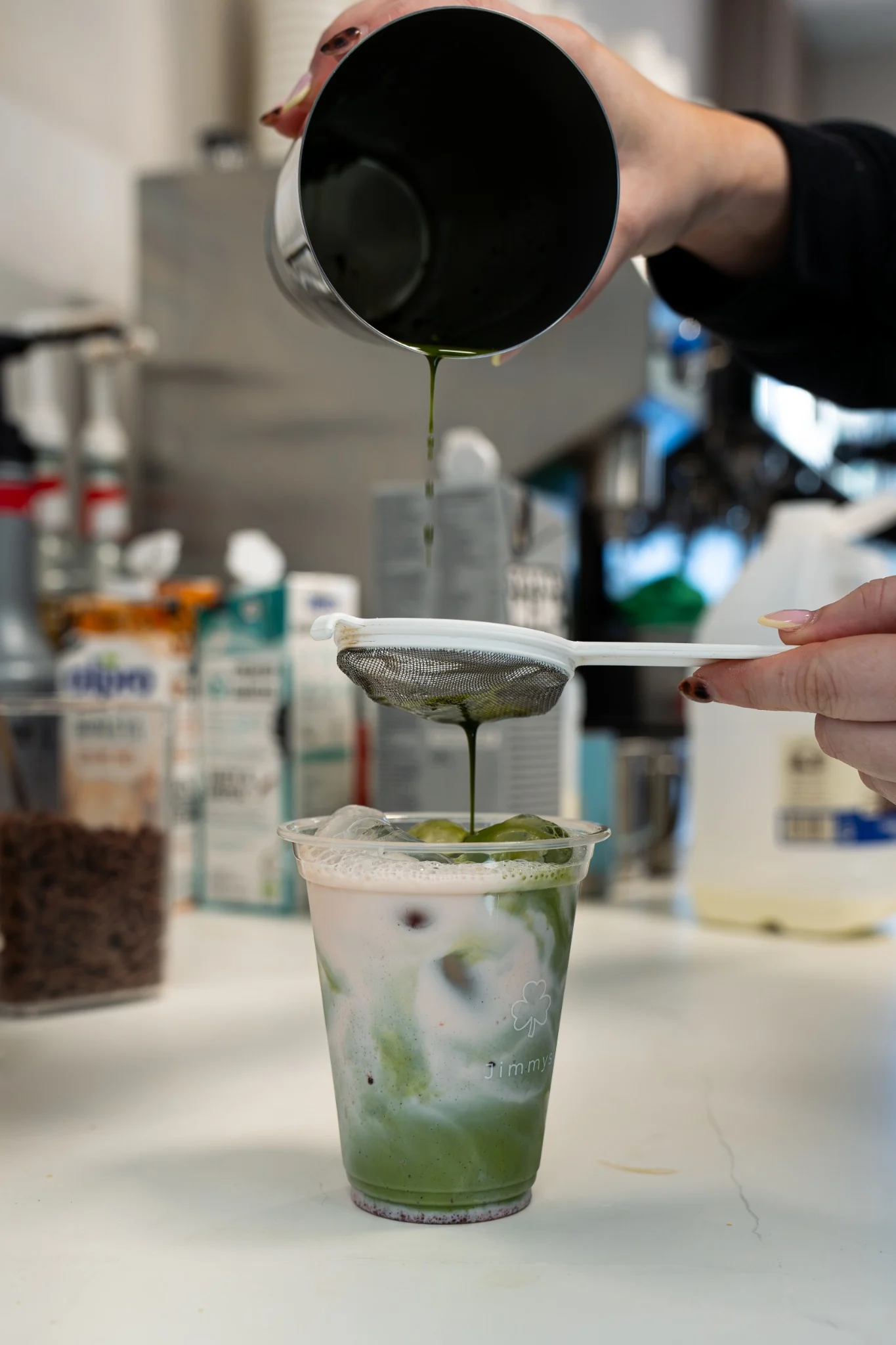 Matcha being strained into an iced drink at Jimmy’s