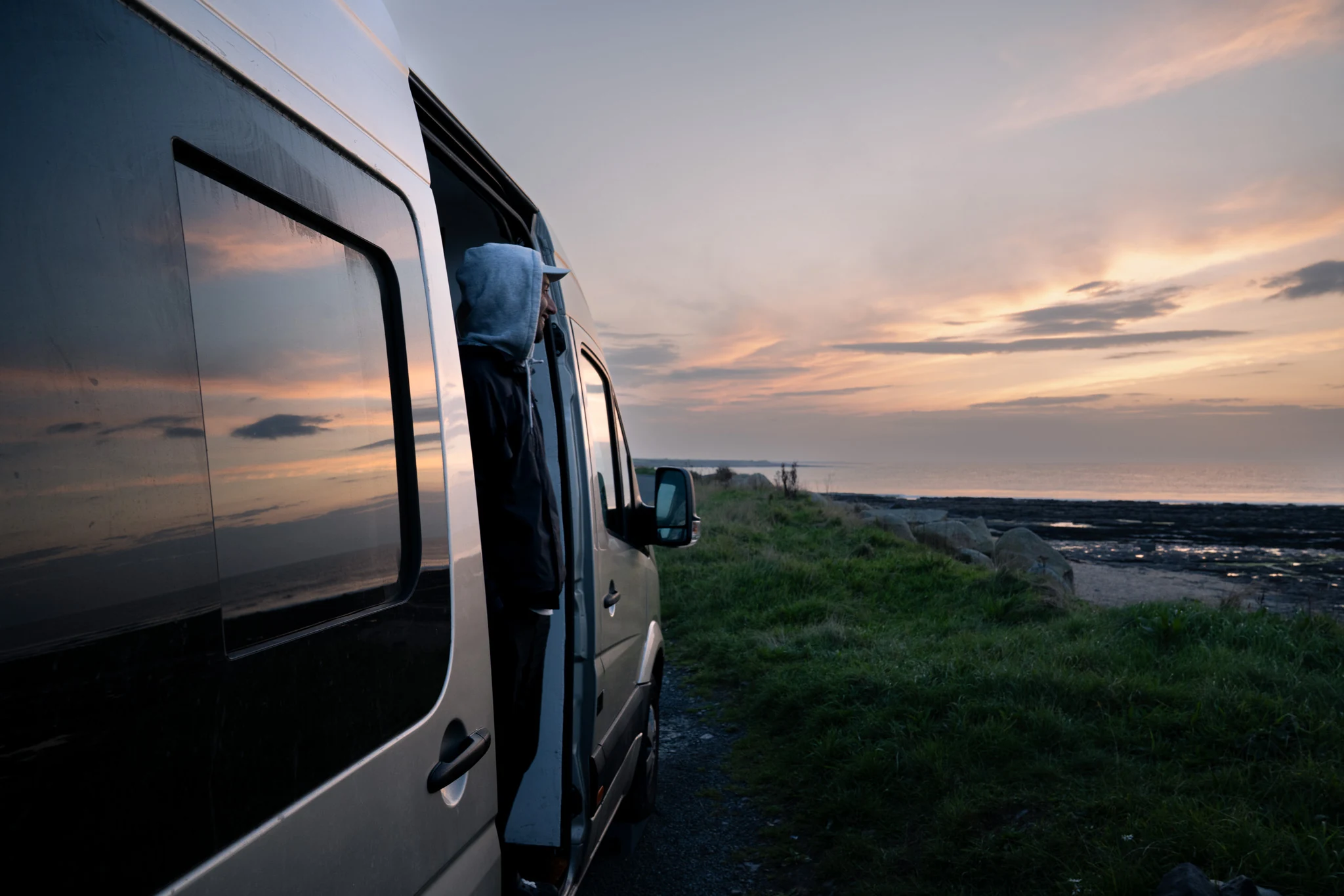 Camper van beside the Atlantic coast at sunset in the west of Ireland