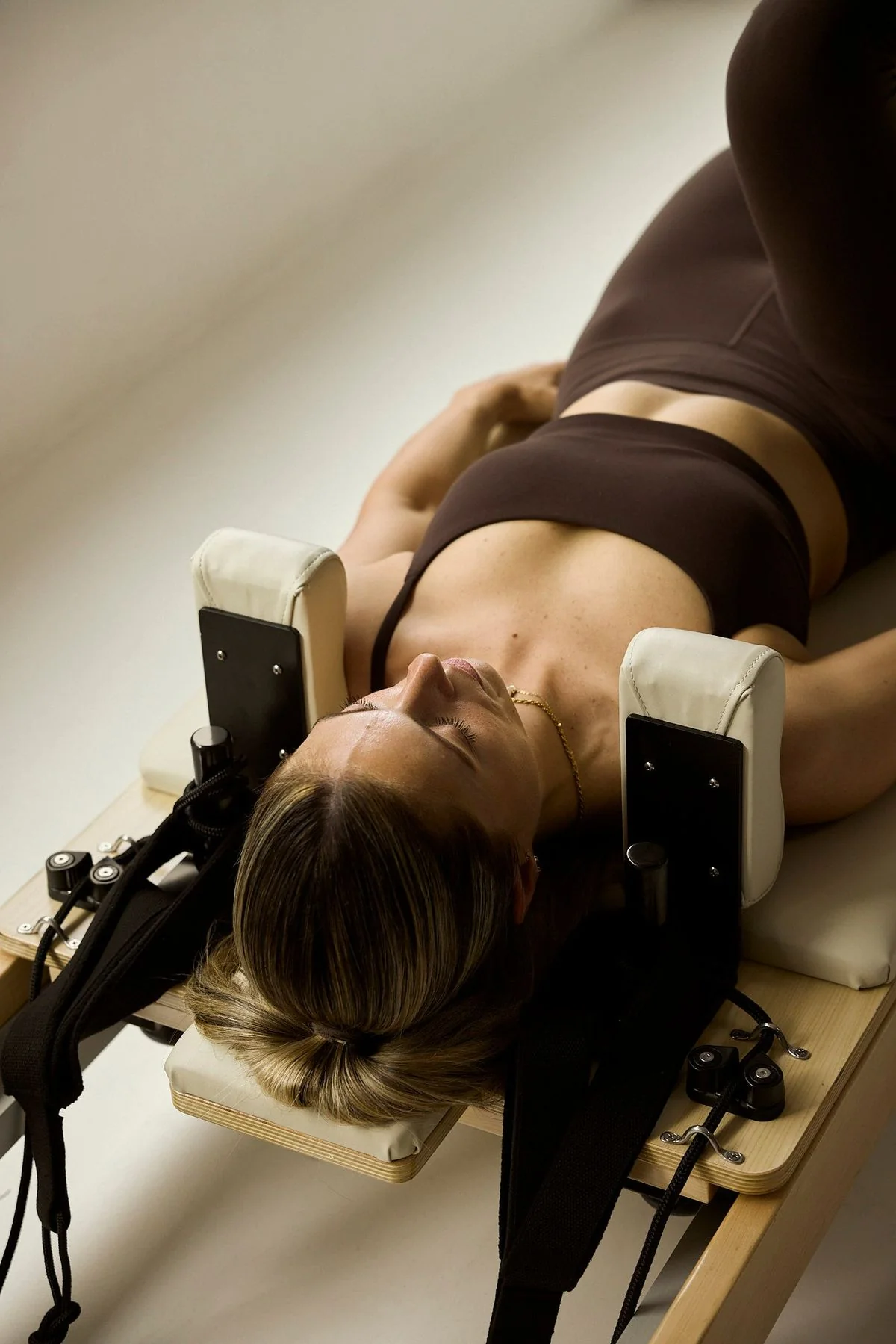 Pilates client resting on reformer equipment