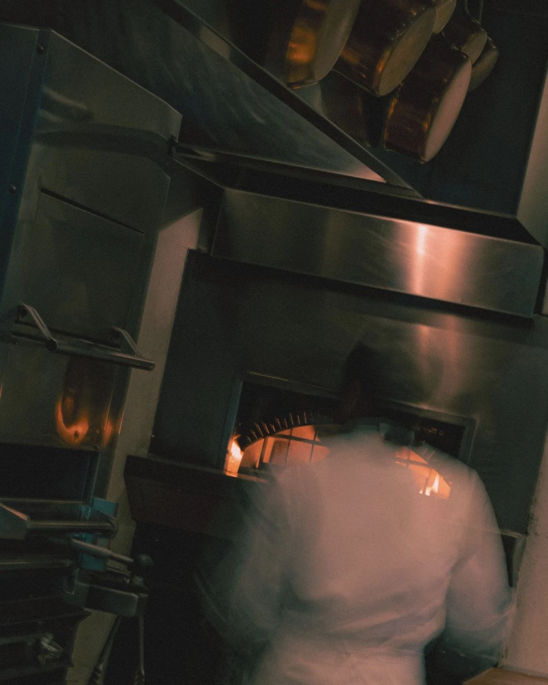 Chef moving through a warm restaurant kitchen